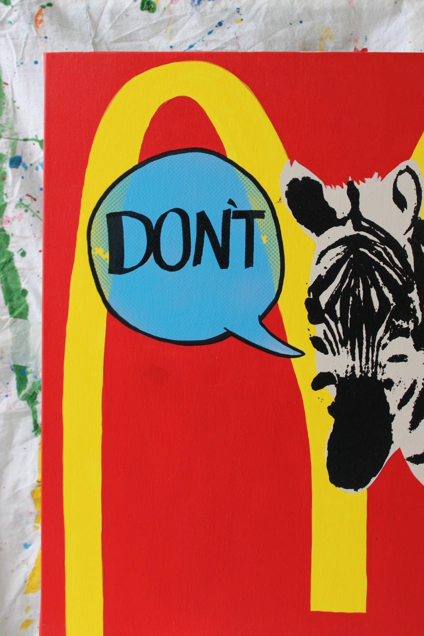 "Close-up view of the zebra in 'DON'T' by Let Z Be Studio, emphasizing the black and white stripes and the vibrant blue speech bubble."