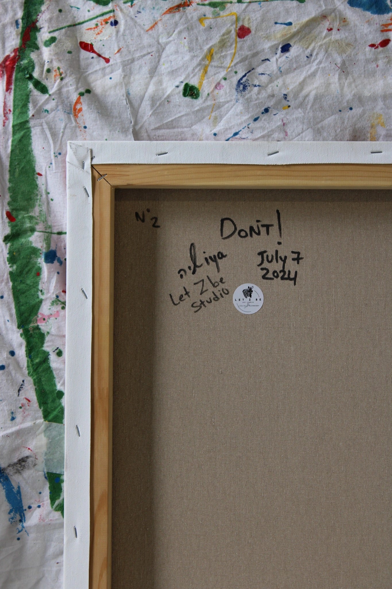 "Back view of the painting 'DON'T' by Let Z Be Studio, showcasing the studio's official zebra logo alongside the artist's signature and title of the piece."