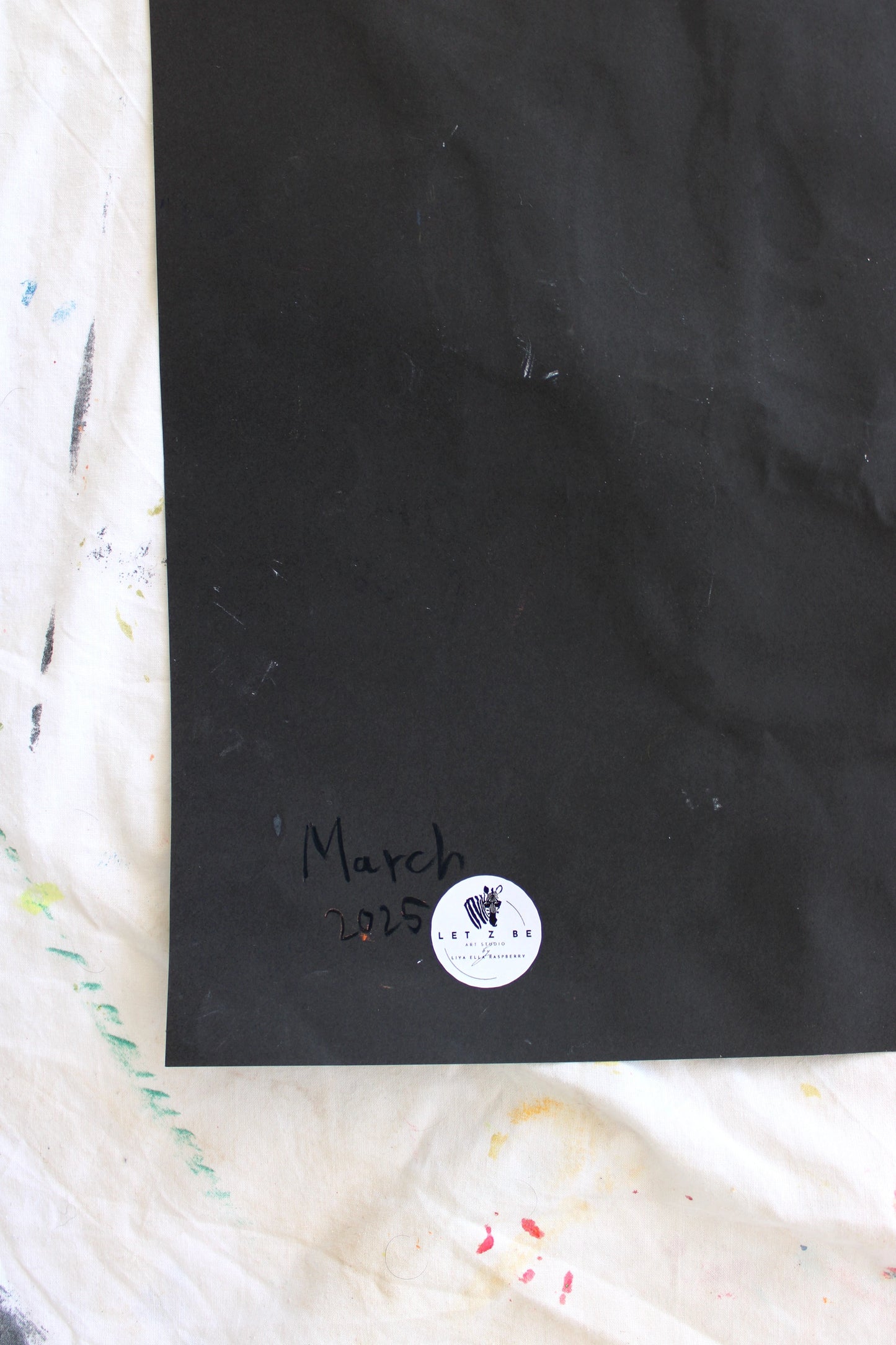 "Close-up image of the back of a black paper, featuring the artist’s signature, a 'March 2025' date, and a 'Let Z Be' logo sticker, symbolizing the authenticity of the artwork."