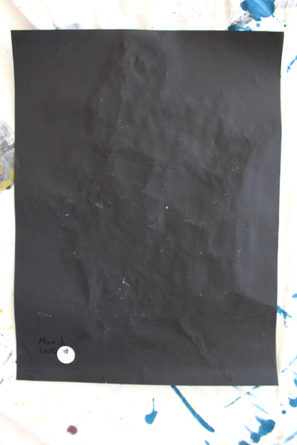 "The back of a black paper with slight creases, featuring the date 'March 2025' written in ink and a 'Let Z Be' logo sticker at the bottom corner, marking the authenticity of the artwork."