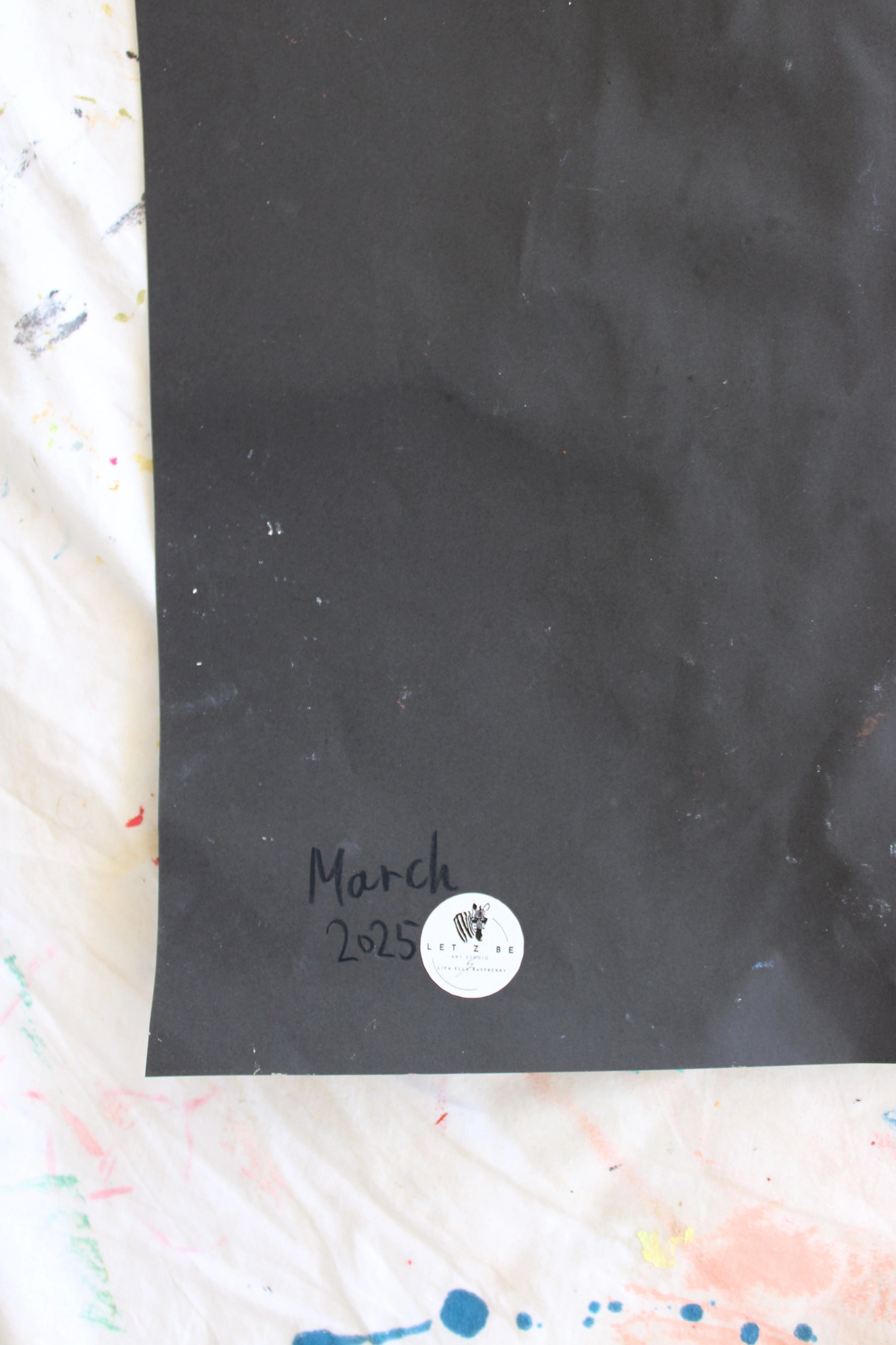 "Close-up image of the back of a black paper, featuring the artist’s signature, a 'March 2025' date, and a 'Let Z Be' logo sticker, symbolizing the authenticity of the artwork."