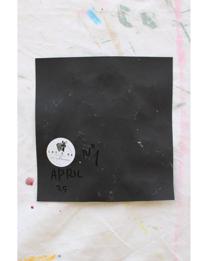 "Back of artwork showing signature, date, and Let Z Be logo sticker on black paper."

