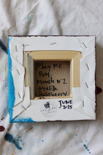 "Backside view of small square canvas artwork titled 'Play Me. Boy. Mouth nº2' signed by artist Liya Ella Raspberry, dated June 2025, with Let Z Be logo sticker and handwritten signature on raw canvas and wood frame."